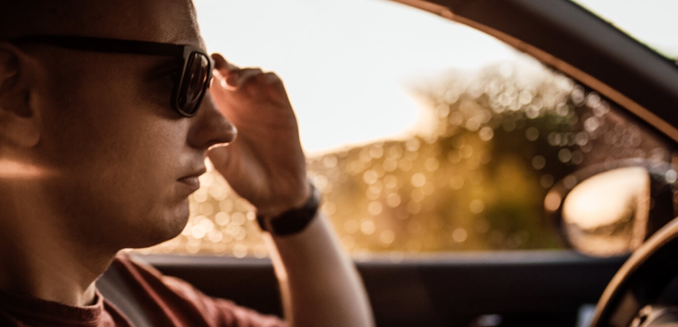 Man wearing sunglasses looking away while sitting in car seen through  window stock photo